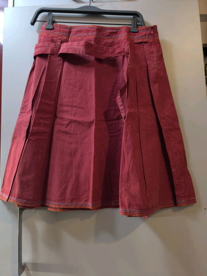 Skirt used, knee-length with flared cut and watermelon color