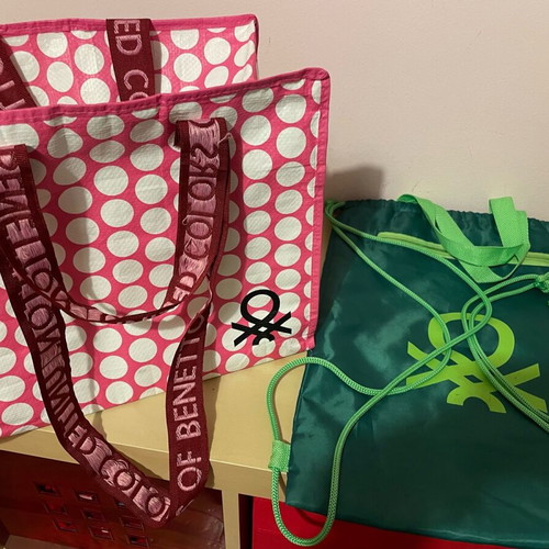 Benetton travel accessory set with pink shoulder bag and green drawstring backpack
