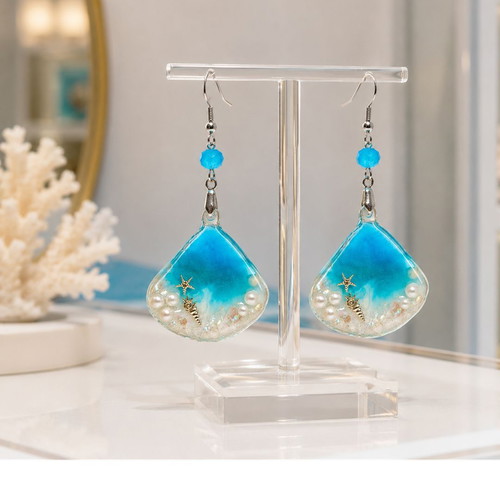 Handmade earrings with stars, shells, pearls, and crystals in resin