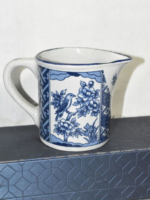 Vintage ceramic jug blue and white with bird and floral motifs used