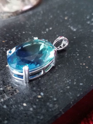 Pendant with blue lab topaz in silver-plated base like new