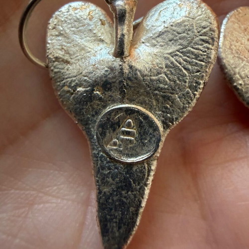 Heart-shaped dangling earrings used, silver color