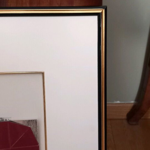 Photo frame with gold and black passepartout finish