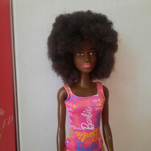 Barbie doll with afro hair and pink logo dress