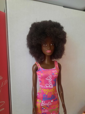 Barbie doll with afro hair and pink logo dress