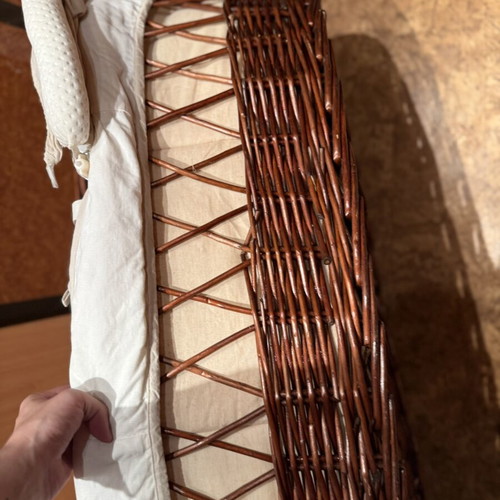 Baby bassinet with woven wicker base and hood