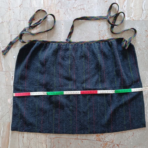 Traditional black apron with vertical stripes used