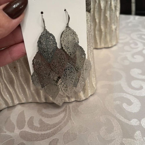 Silver dangling earrings with leaf design used