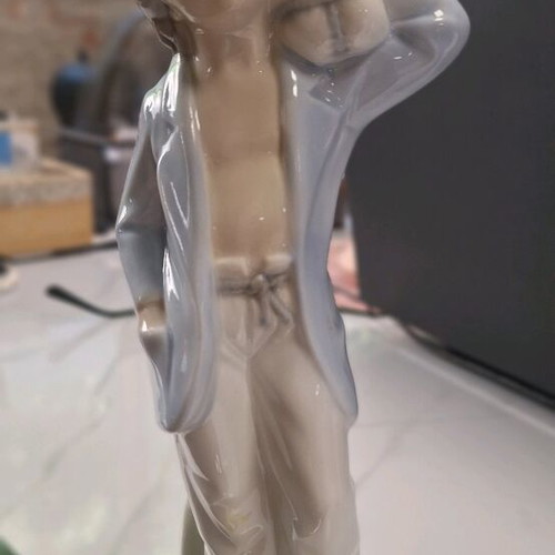 Porcelain figurine boy with bundle of wood like new