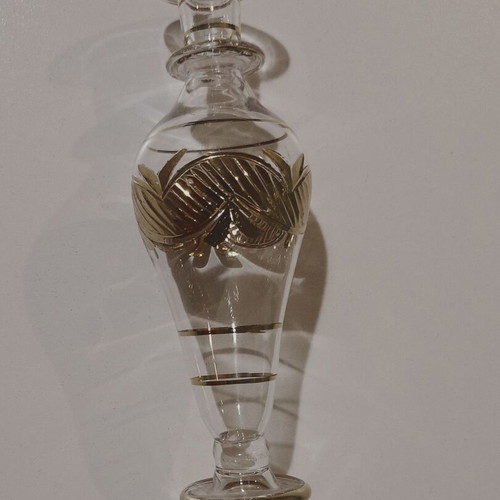 Glass perfume bottle used with golden accents and cap