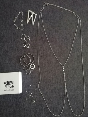 Various silver jewelry including earrings, body chain, rings, and necklace
