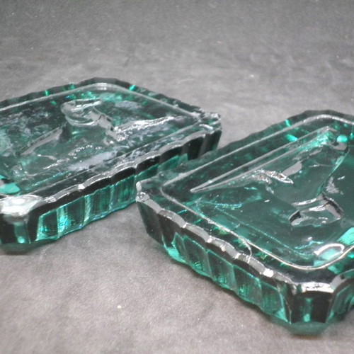 Antique ashtrays pair used with embossed dogs in dark green glass