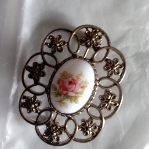 Metal brooch with porcelain detail used