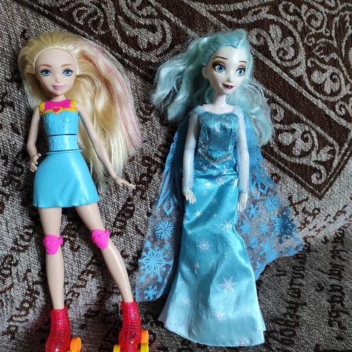 Elsa (Frozen) and Barbie dolls used with magic roller skates