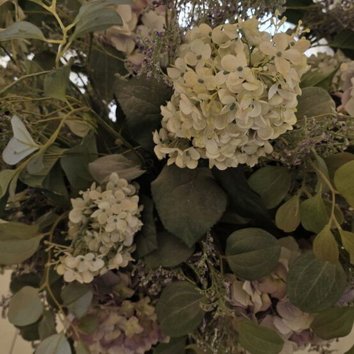 Artificial flower arrangement with hydrangeas and eucalyptus in clay floor vase