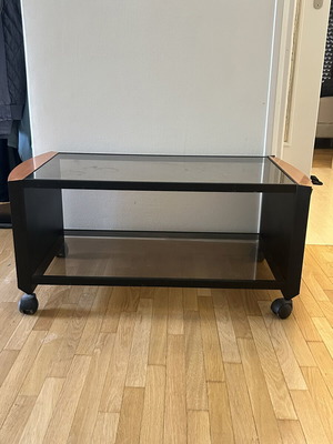 Coffee table with glass top, black metal frame and wooden corners