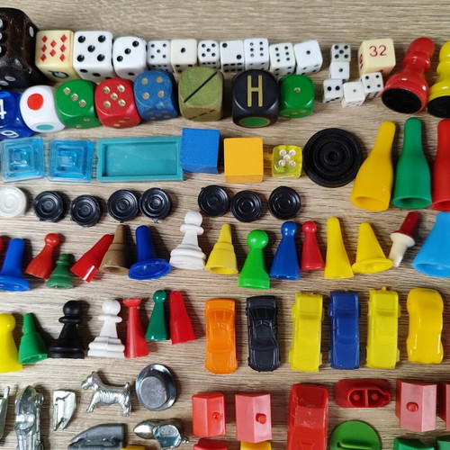 Lot of used board game parts including pawns, dice, cards, and hourglasses