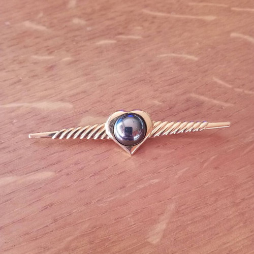 Vintage brooch in gold color with hematite stone, like new