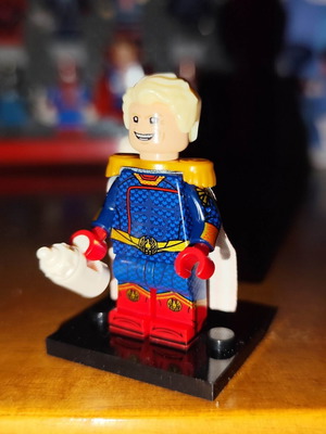 Homelander figure like new with base, two heads, cape, and bottle