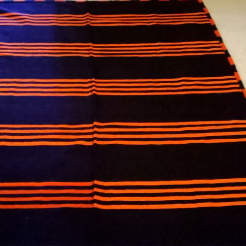 Woven blanket used orange and blue in two joined pieces