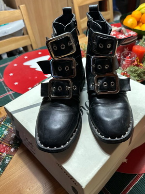 Black leather combat boots used with multiple buckles and metal details