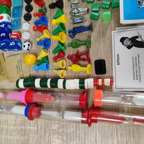Lot of used board game parts including pawns, dice, cards, and hourglasses