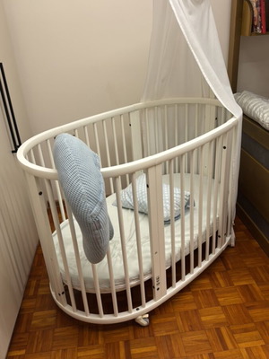 Stokke Sleepi Ve convertible baby cot used with mosquito net and wooden musical toy