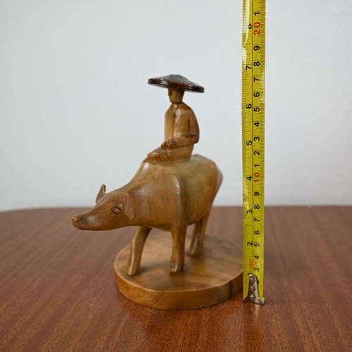 Vintage wooden carving of a man on a buffalo used