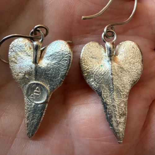 Heart-shaped dangling earrings used, silver color