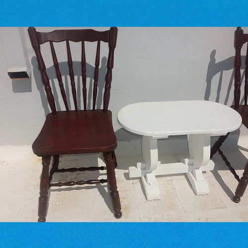 Wooden set with oval white table and 2 traditional dark chairs used for outdoor