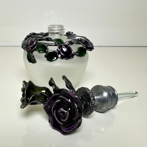 Vintage ornate perfume bottle with frosted glass and metal floral decoration