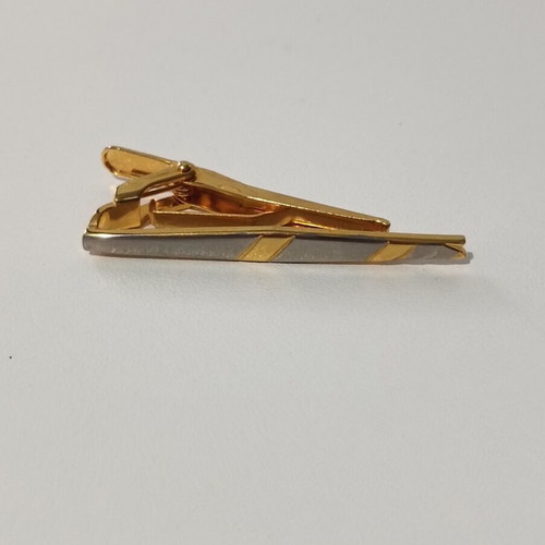 Tie clip used, gold color with silver accents
