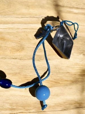 Handmade decorative charm with blue details and metal ship