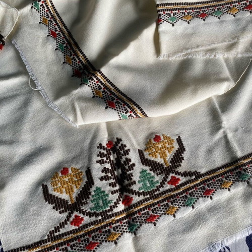 Woven fabric on loom new, thin cream wool textile with embroidery