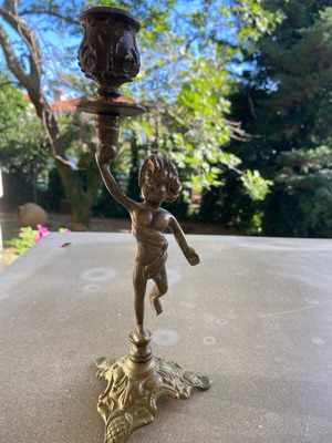 Bronze single candlestick used with decorative putti
