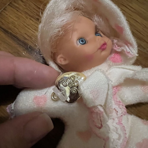 Doll with hood, missing one leg and one arm, slight tear