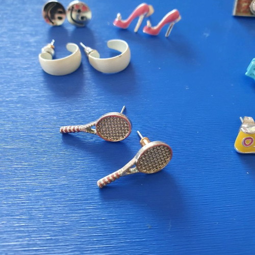 Unique earrings used with designs of swimsuits, rackets, sunglasses