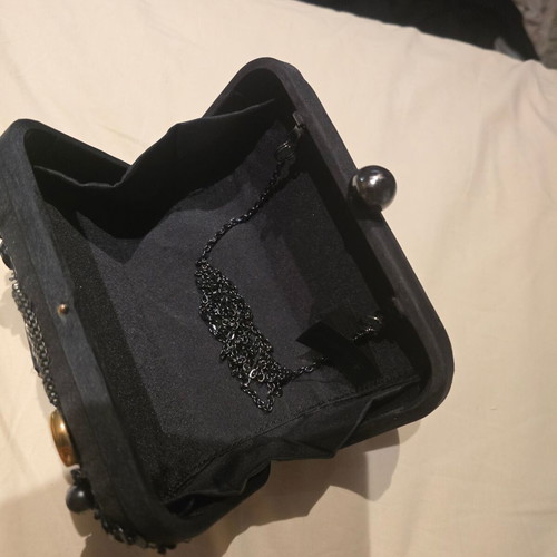 Black handheld evening bag used with small missing stone