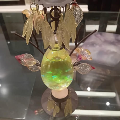Decorative candle holder with metal tree base, used