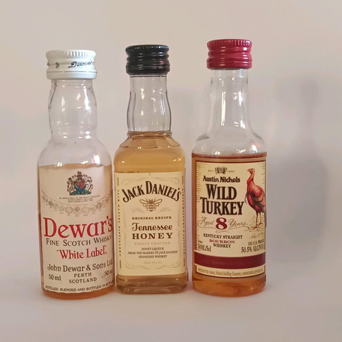 7 mini whiskey bottles, sealed plastic