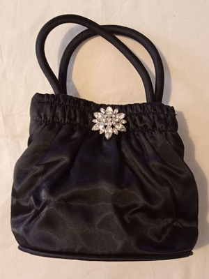 Small black evening handbag used with rhinestone brooch