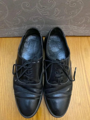 Men's black leather shoes with heel needing replacement