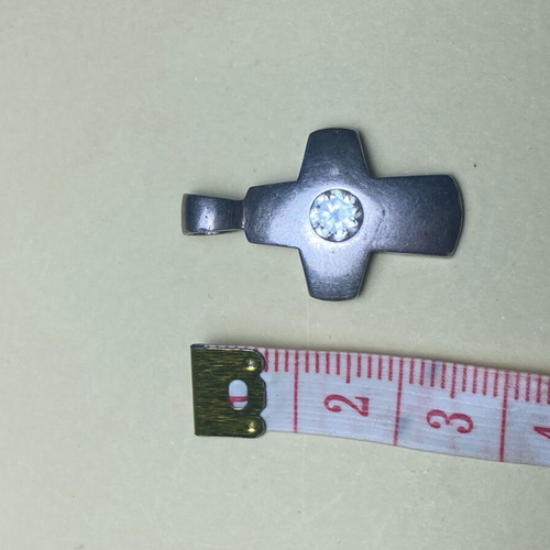 Silver cross used with stone