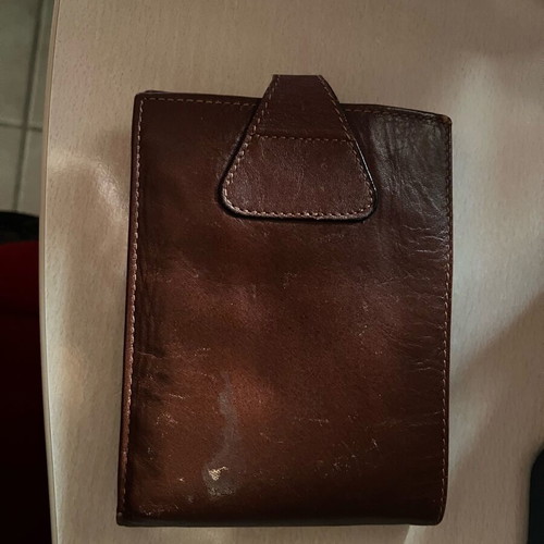 Brown wallet used with multiple card slots and belt-style clasp