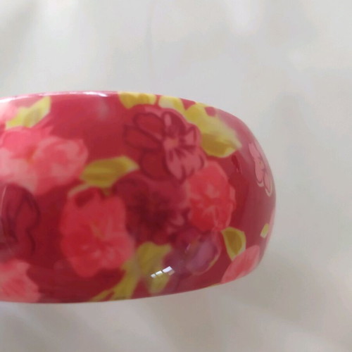 Bracelet asymmetric with pink flowers and green leaves on red background