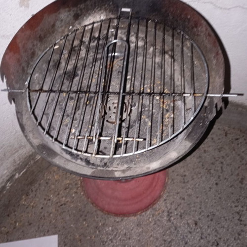 Portable vintage charcoal barbecue with red central leg, used