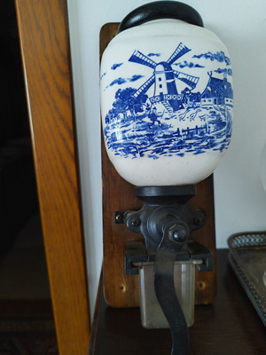 Wall-mounted coffee grinder used with ceramic container and blue windmill design