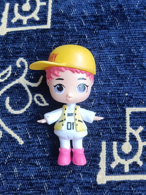 Doll figure with yellow cap and pink hair