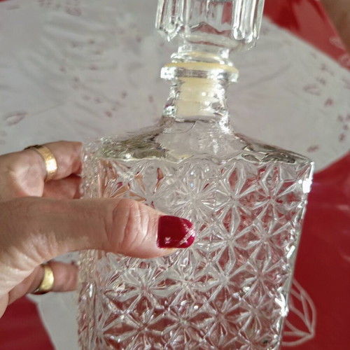 Vintage glass decanter with embossed geometric design and stopper