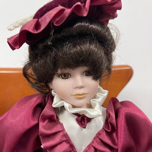 Porcelain doll used with satin and velvet dress, broken arm